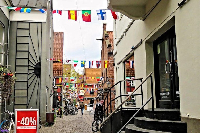 Una calle con una escalera, bicicletas y banderas. 5
