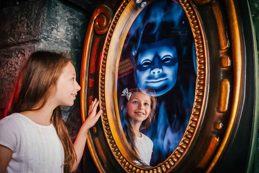 A child looking at a mirror with a blue-tinted reflection. 5