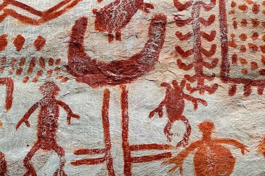 Antiguas pinturas rupestres en ocre rojo con figuras humanas y diseños abstractos. 5