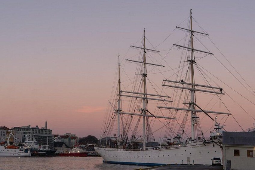 Un gran barco velero atracado en un puerto con edificios al fondo. 5
