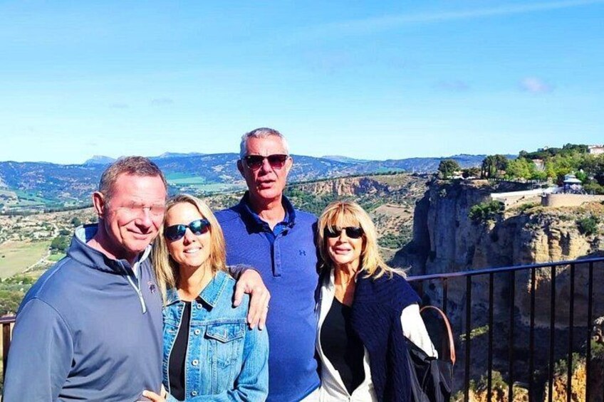 Un grupo de personas en un balcón con vistas a un paisaje montañoso. 3