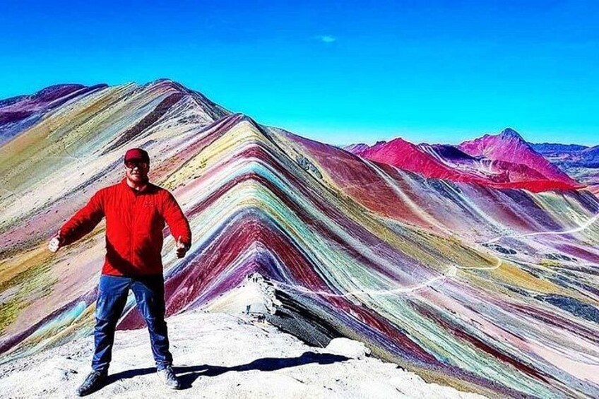 Une personne se tient devant une chaîne de montagnes aux couleurs vives. 3