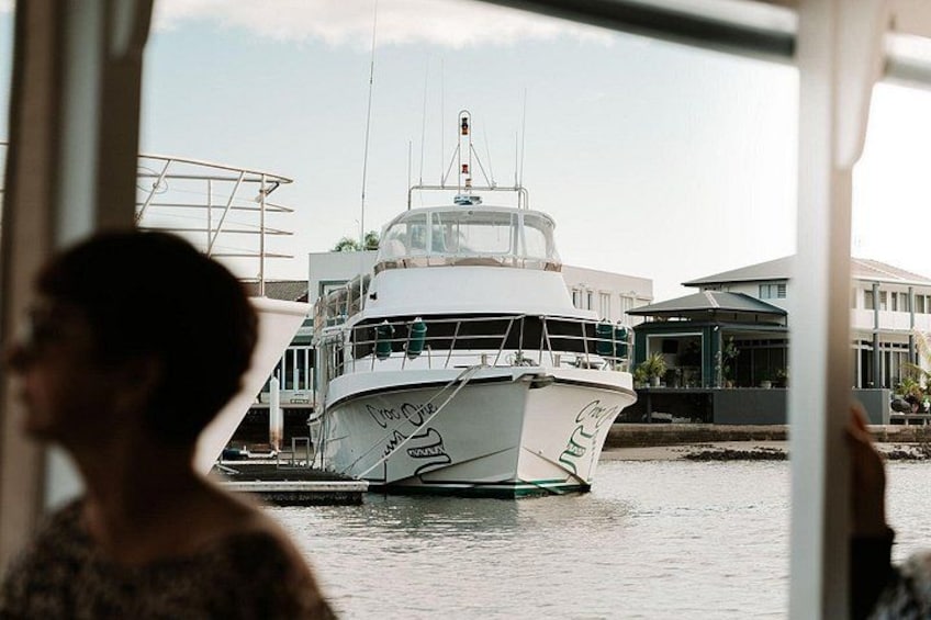 Ein weißes Boot liegt in einer Marina vor einer Gebäudereihe. 2