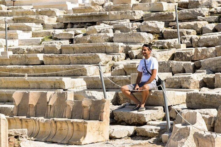 A person sitting on stone steps in an ancient ruin. 4