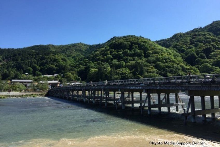 A long wooden pier extending into a body of water, surrounded by lush green hills. 2