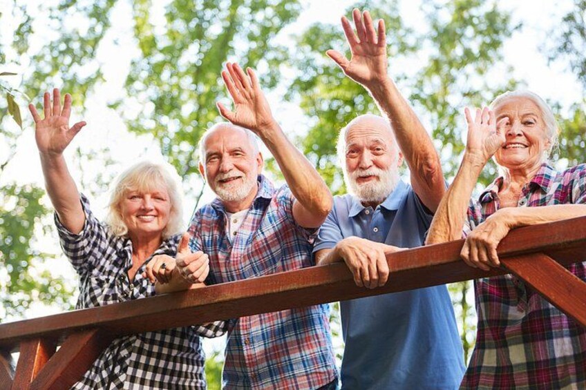 Cuatro personas al aire libre alzando las manos. 2