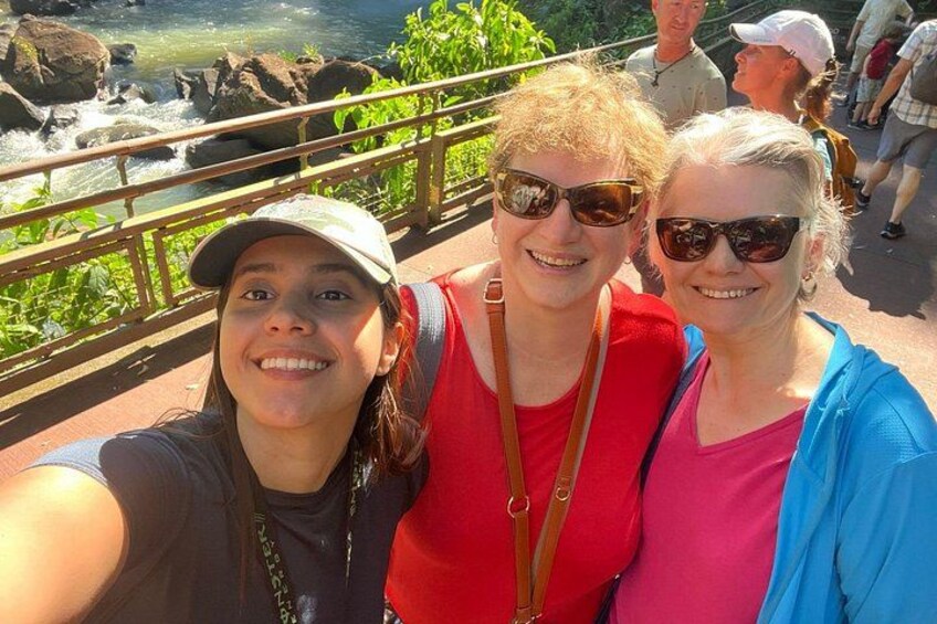Un grupo de personas tomándose un selfie en un puente, con un río y rocas al fondo. 4