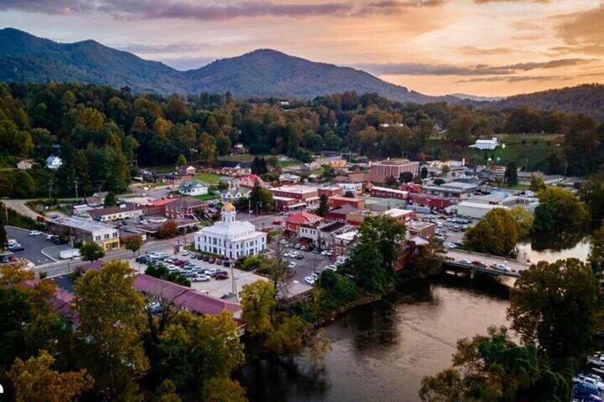 A town with a river, surrounded by mountains. 1