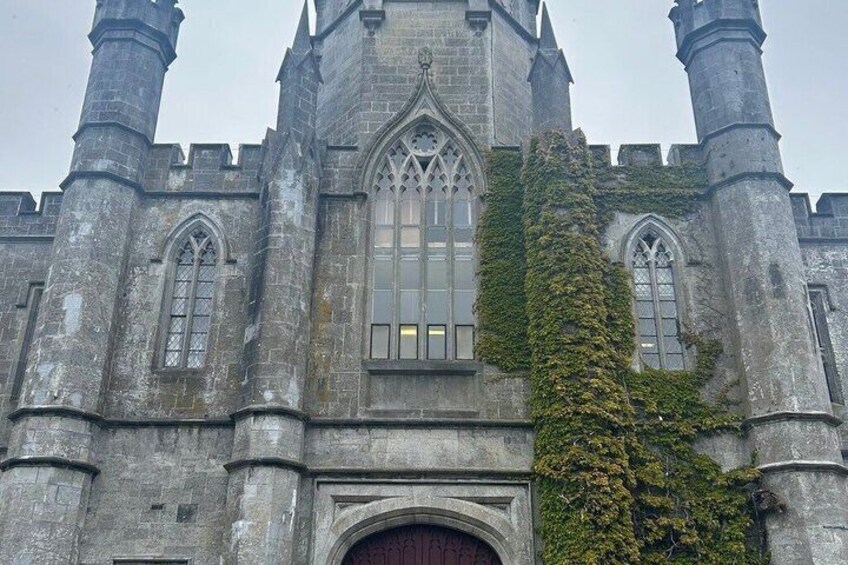 A historic stone building with arched windows and a large central door. 5