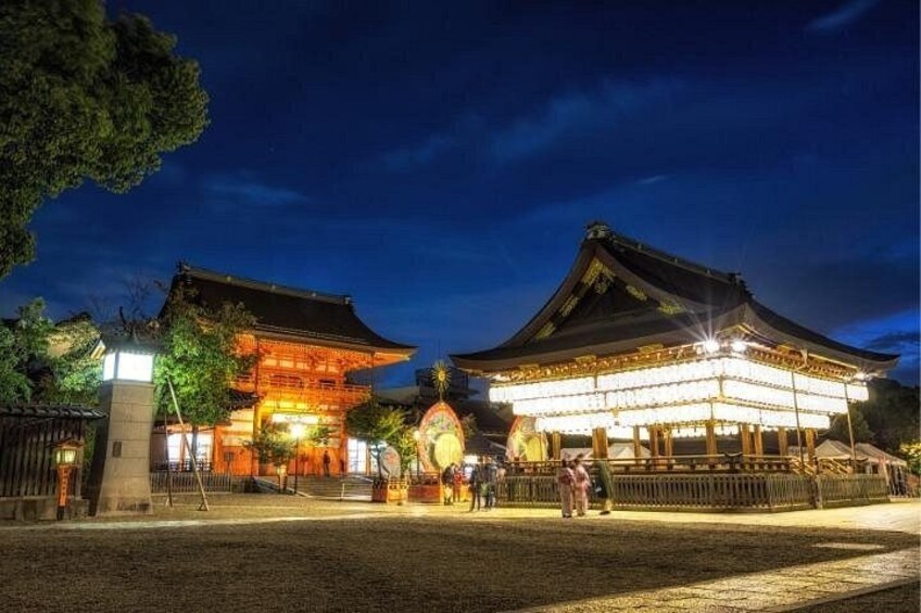 Un edificio tradicional japonés de noche con faroles iluminados y una puerta grande y ornamentada. 5
