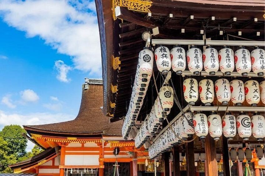 Un edificio tradicional japonés con tejado curvo y una serie de faroles colgantes con inscripciones. 4
