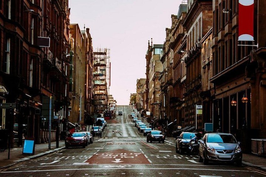 A city street with parked cars, buildings, and a red banner. 2