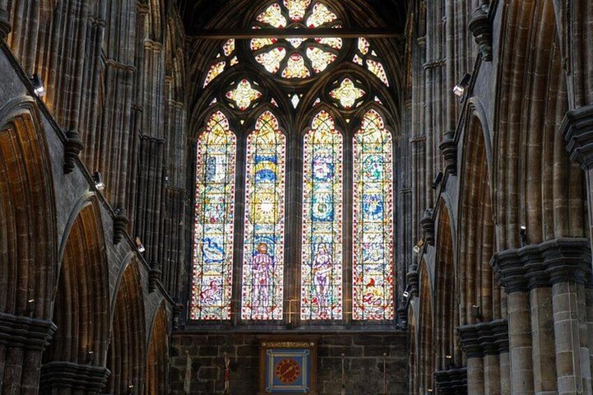 A Gothic-style stained glass window with intricate designs and a stone archway. 4