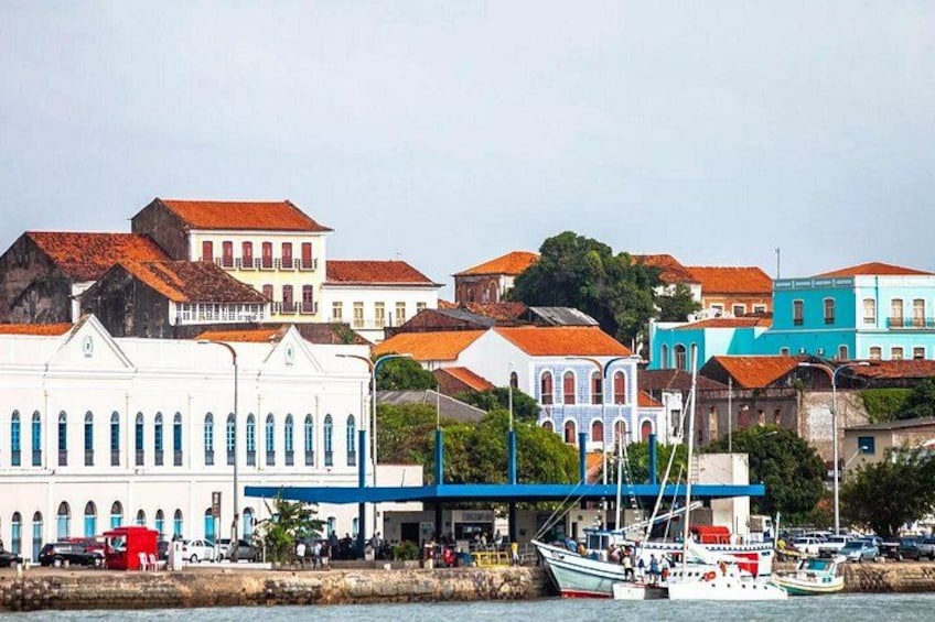 Un pueblo costero con edificios de colores, un muelle con barcos y un puente. 2