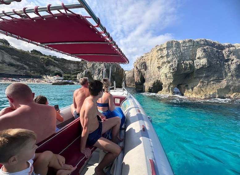 A boat with people on a rocky coastline. 4