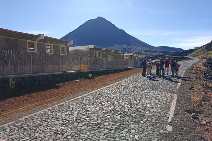 Un grupo de personas sobre un sendero rocoso, con una montaña al fondo. 5