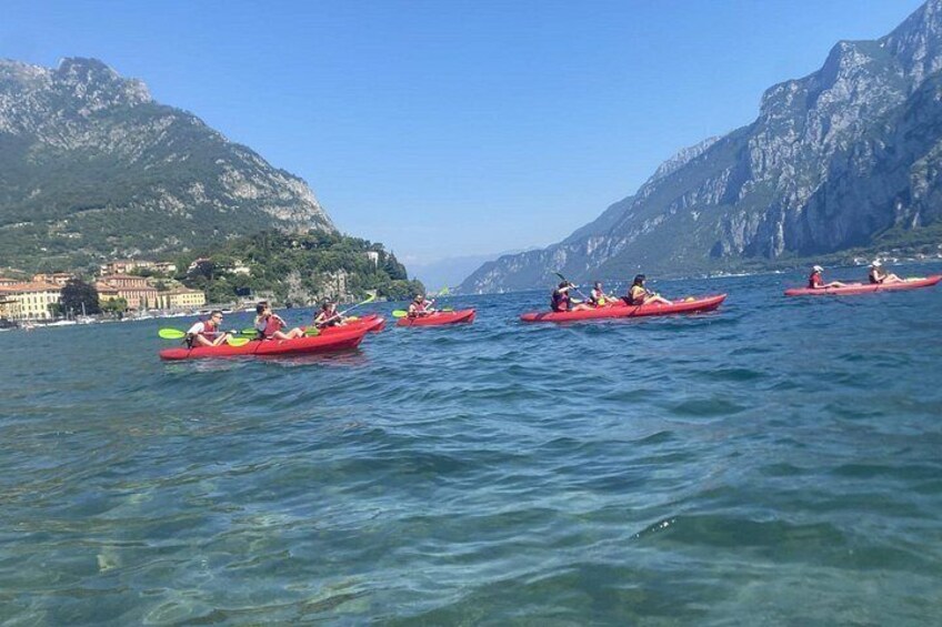 People kayaking on a calm lake with mountains in the background. 5