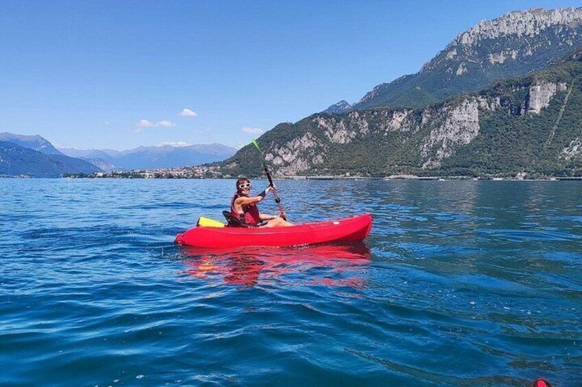 A person kayaking on a calm lake with mountains in the background. 4