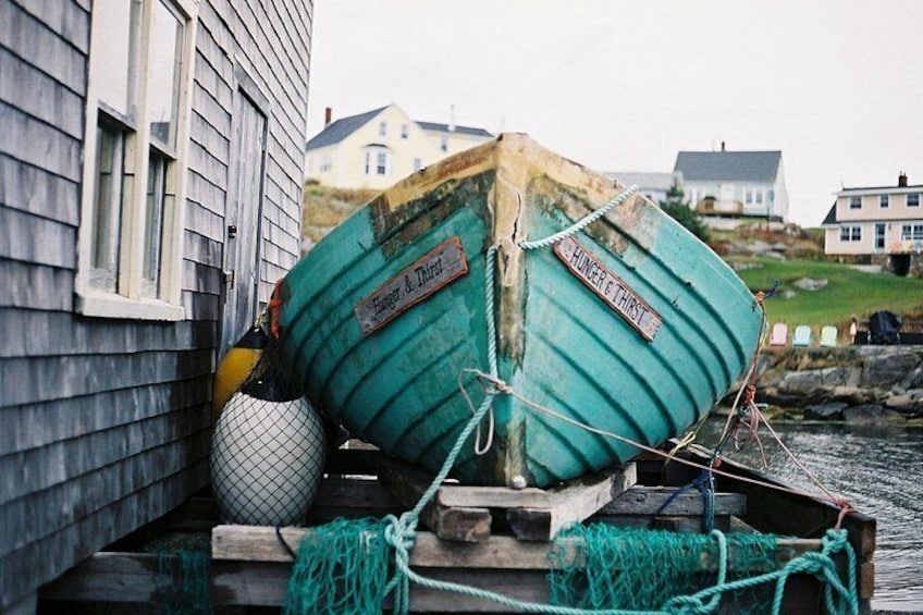 Two boats tied to a dock with a house in the background. 3