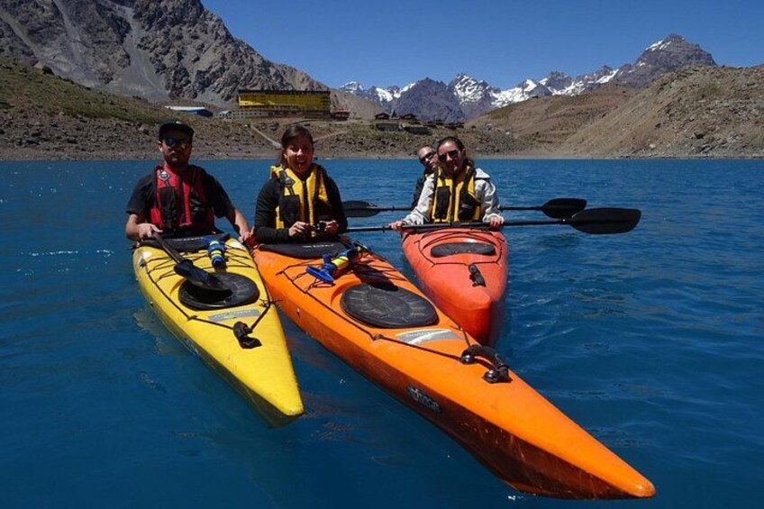 Three people in kayaks on a calm lake with mountains in the background. 5