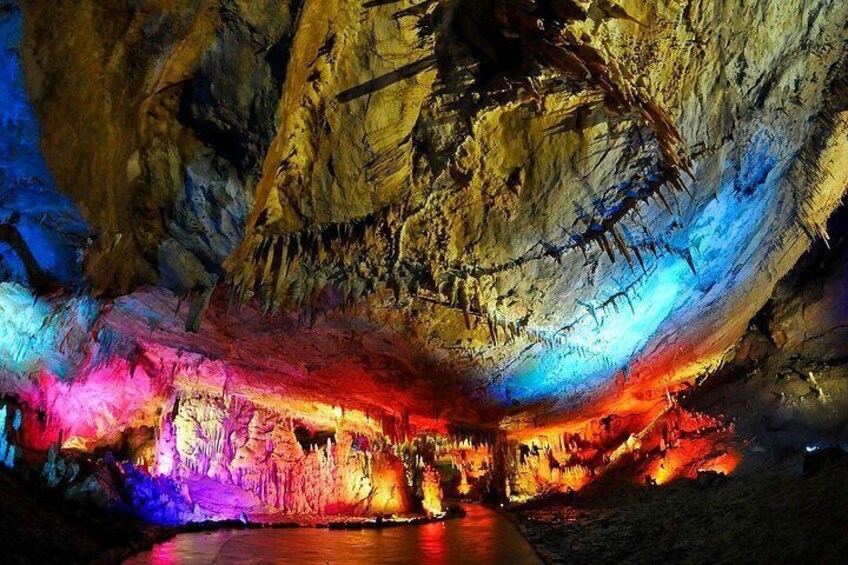 Eine Höhle, beleuchtet mit bunten Lichtern, Stalaktiten und Stalagmiten. 3