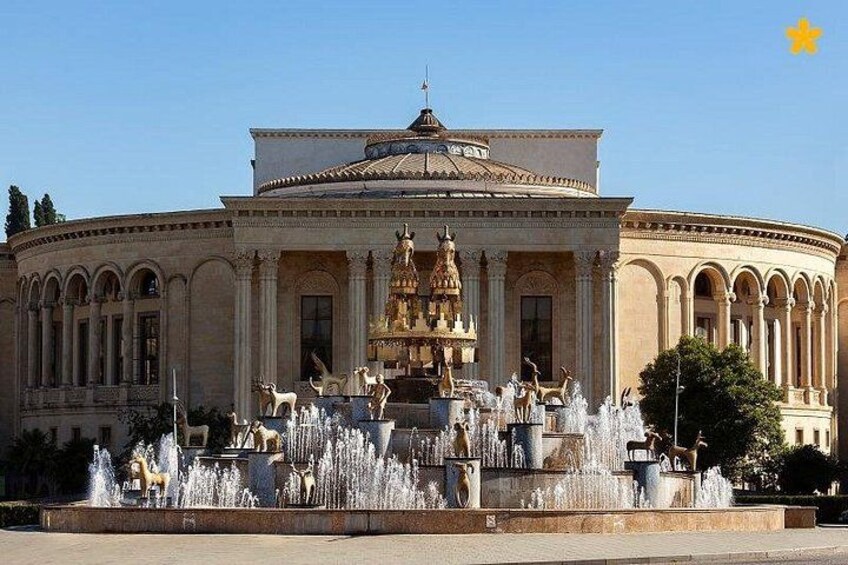 A classical building with a central fountain and statues. 2
