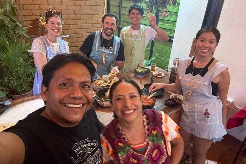 A group of people in a kitchen with cooking utensils and food. 2