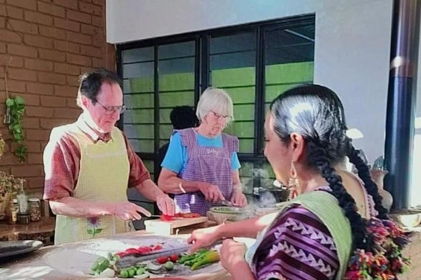 A person cutting vegetables at a counter with a window in the background. 3