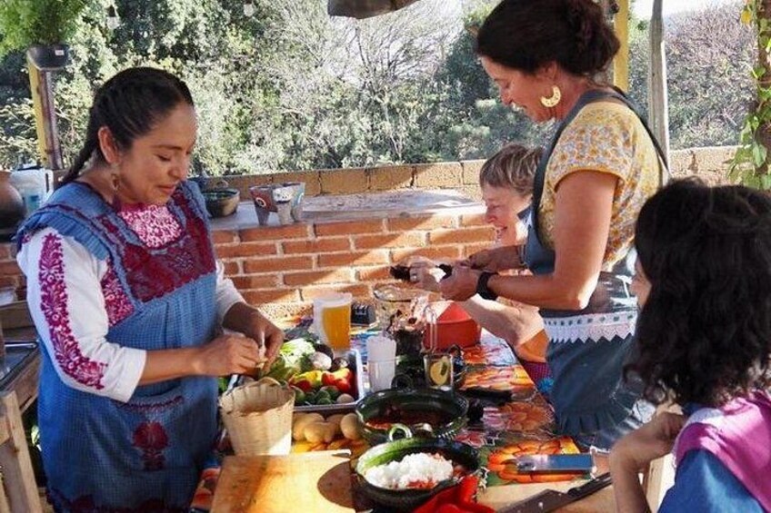 People preparing food outdoors with a brick oven and various ingredients. 5