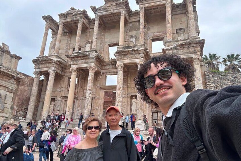 A historical building with columns and arches, surrounded by tourists. 1