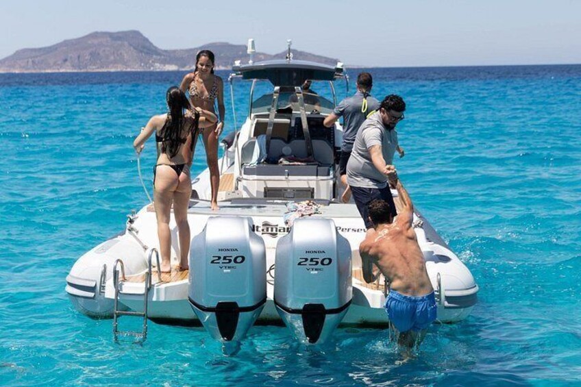 A boat with two people standing on the deck, a dog on the water, and a person in the water. 3