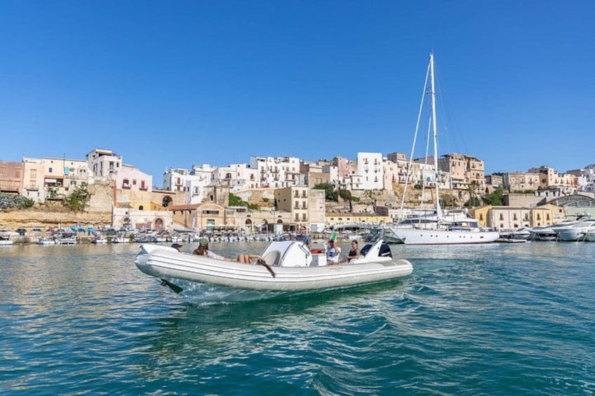 A coastal town with boats on the water, buildings in the background, and a clear sky. 2
