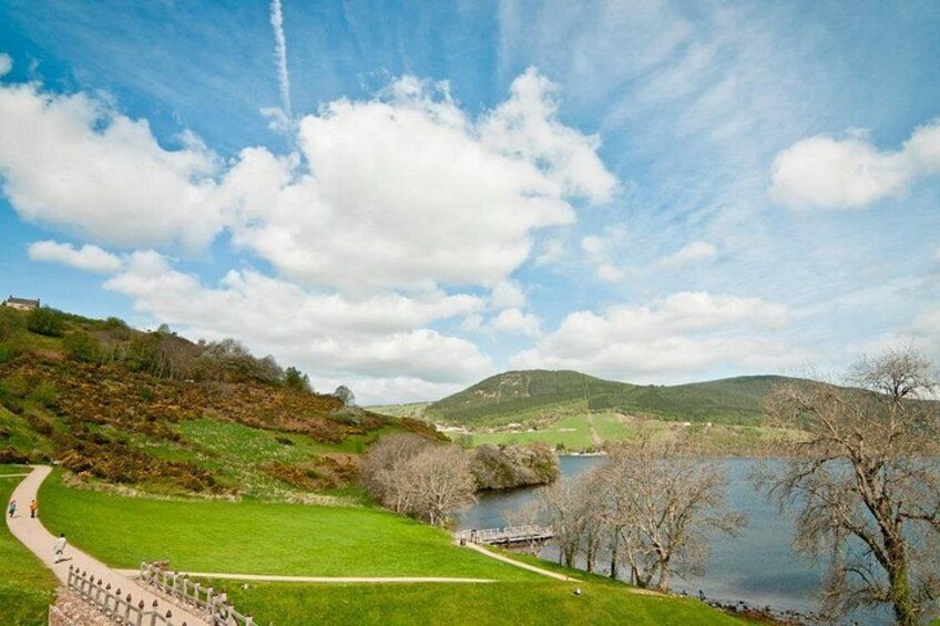 A river, grassy banks, a walking path, and distant hills. 3