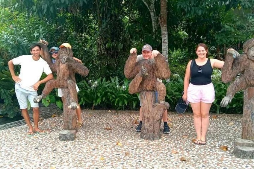 People posing with large tree stump sculptures. 1