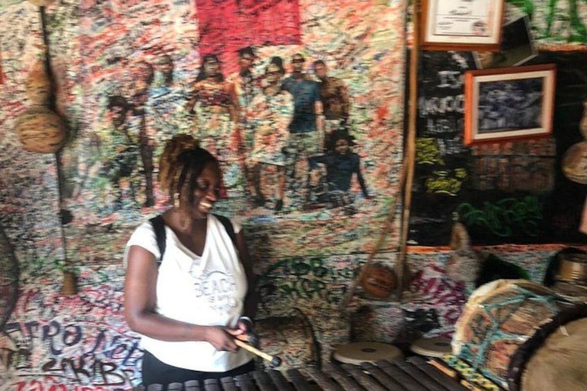 A person playing a drum in a room with graffiti on the walls. 2