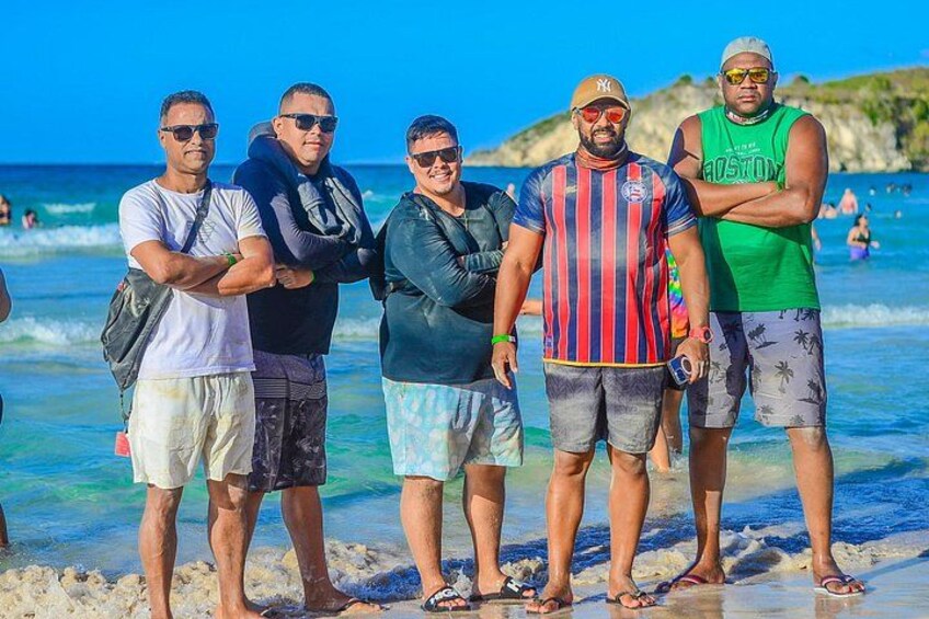 A group of people standing on a beach with the ocean in the background. 2