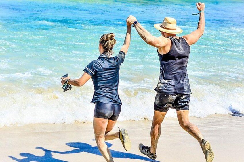 Two people running on a beach with ocean waves in the background. 3