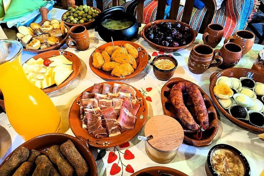 Una mesa con diversos platos, incluyendo carnes, quesos y aceitunas. 2