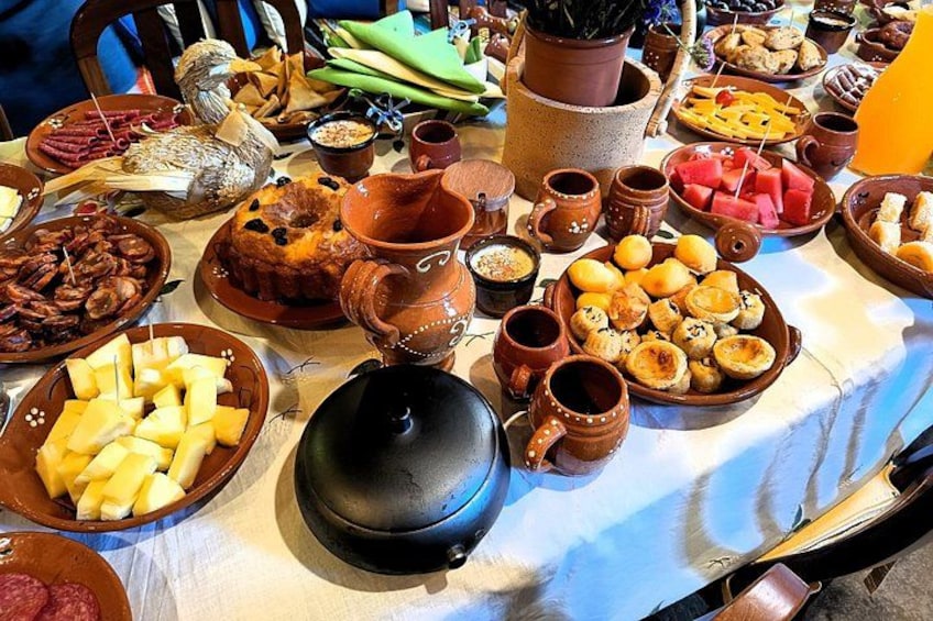 Una mesa con diferentes platos, incluyendo una olla grande, tazones de comida y varias tazas pequeñas. 5