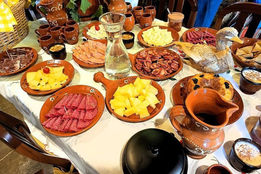 Una mesa con diferentes alimentos y cerámica tradicional. 4