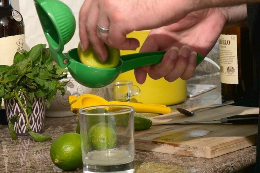 Jemand presst Limetten in ein Glas. 5
