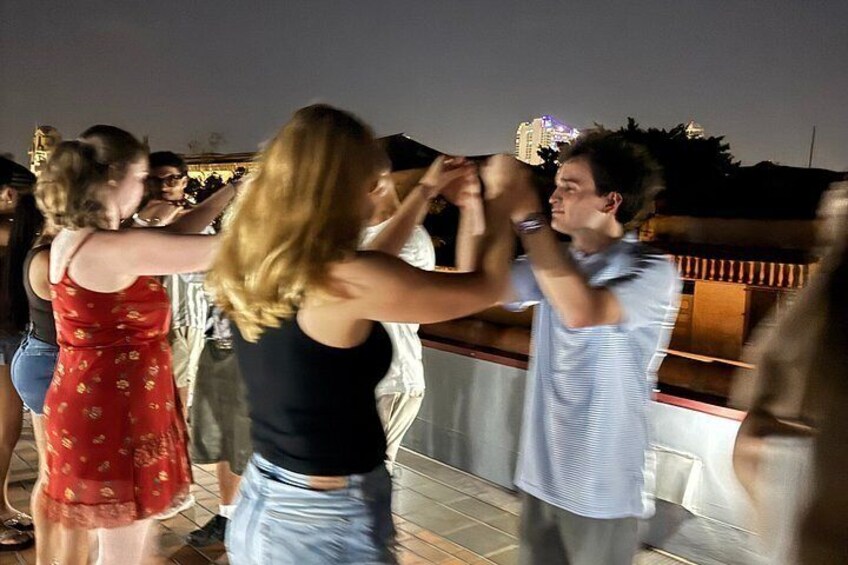 People dancing on a rooftop at night. 5