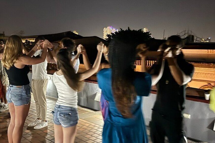 A group of people dancing on a rooftop at night. 4