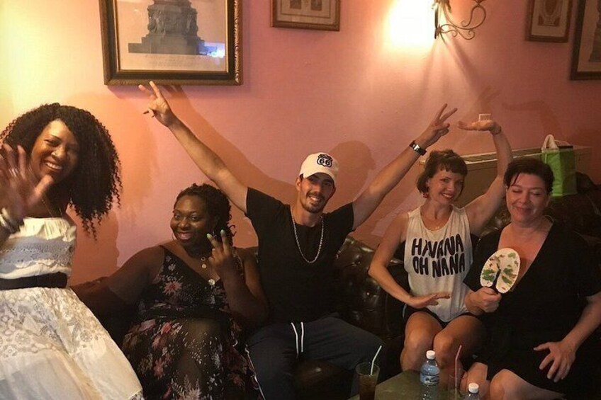 A group of people sitting on a couch in a room with a framed picture on the wall. 2