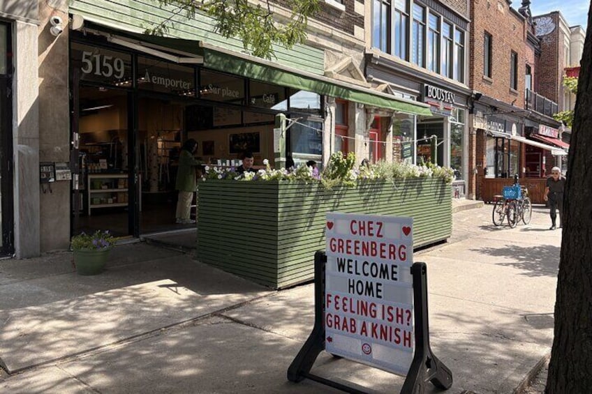 En butik med ett skyltfönster där det står: ”Välkommen hem till Chez Greenberg”. 2