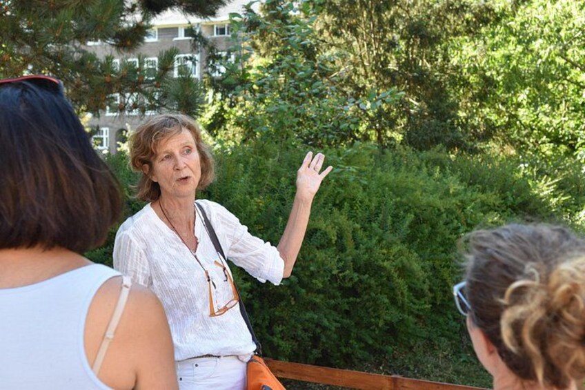 A person gesturing while speaking to a group of people outdoors. 2
