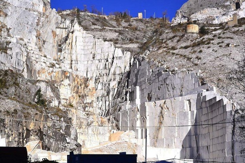 Une falaise rocheuse surmontée d’une imposante structure en marbre blanc. 1