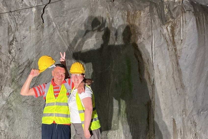 Zwei Personen mit Schutzhelmen und Warnwesten stehen vor einer Felswand. 3
