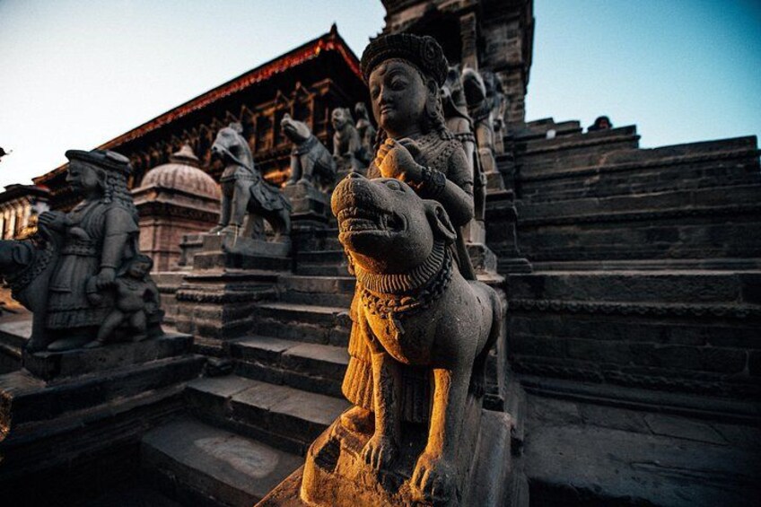 A stone statue of a deity on a horse, surrounded by other statues and a temple structure. 2