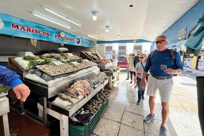 Mercado de mariscos con diversos pescados y productos del mar exhibidos sobre hielo. 3